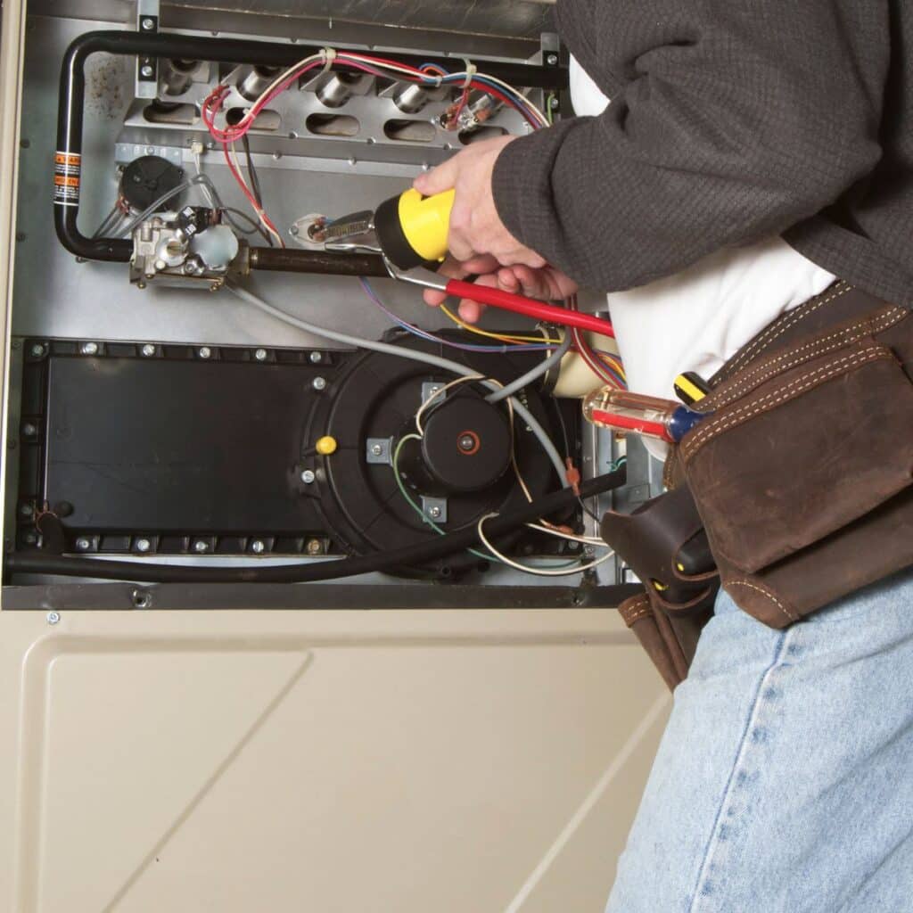 man repairing a heating unit for winter