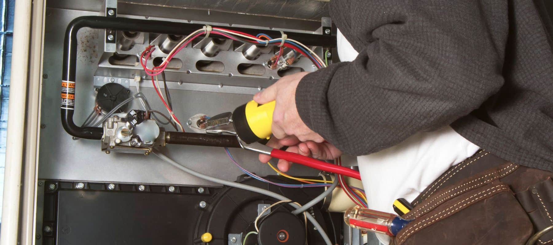 man repairing a heating unit for winter